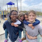 The Child's Primary School Photo #10 - Our 8th grade students love interacting with our younger students. Here 8th grade girls are having fun giving two younger students a ride around the playground!