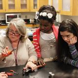 The Orchard School Photo #2 - Seventh graders learn the anatomy of a battery by taking one apart and examining its contents. Understanding how chemical reactions can make electricity can be confusing and these students take time to see the components close-up.