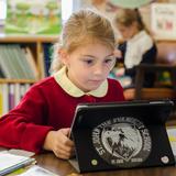St. John the Evangelist Catholic School Photo #4 - Elementary iPad learning. Students in grade K-8 have access to classroom iPads to for testing, Accelerated Reader, reading and math.
