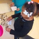 Whitcomb KinderCare Photo #1 - Our Juniour Kindergartners stepped back into time during our Dinosaur unit! Here, a child enjoys writing her name in stones in our prehistoric writing center!