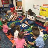Rohan Woods School Photo - Our Early Childhood class (Age 2) watches as Ms. Sullivan creates the colors in the book they are reading-- MOUSE PAINT. "It was magic, one little kiddo said as red and blue made purple!"