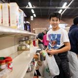 Greensboro Montessori School Photo #17 - A seventh grader bags meals at a local food pantry. Care for oneself, others, and the environment are tenets of Montessori education.