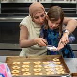 French International School of Oregon Photo #3 - A kindergarten student and her teacher make cookies in the French International kitchen.