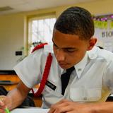 Hargrave Military Academy Photo #2 - A Hargrave cadet in dress whites concentrating on written work at his desk