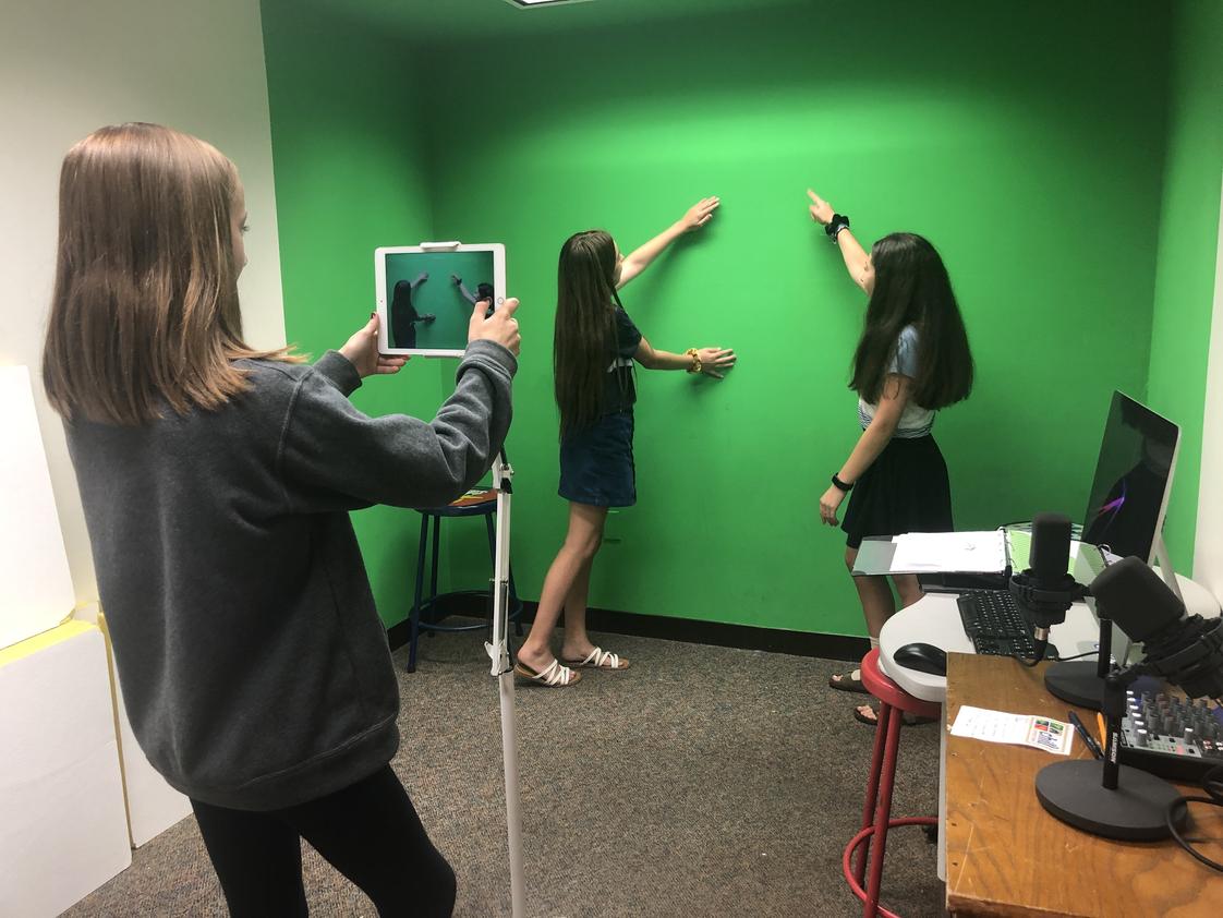 Norfolk Collegiate School Photo - Middle school students use the green room to film a short video for class. The room is equipped with movie editing software, iPads and more for students to utilize.