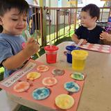 OC Kids Infant & Preschool Photo #14 - Learning all about primary and secondary colors in our Outdoor Art Center. Children enjoy some fresh air and sunshine, while exercising their fine motor skills to use the eye droppers, and color recognition to form their secondary colors.
