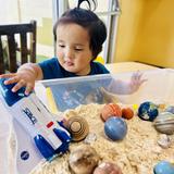 OC Kids Infant & Preschool Photo #13 - Sensory fun in our Infant Classroom. During our Outer Space Exploration week, children of all ages explored different space topics as their developmental level. Here you can see our infants exploring plants and "moon dust". Exercising their hand eye coordination, sensory skills, as well as learning about spheres and shapes.