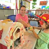 OC Kids Infant & Preschool Photo #15 - Safety Week was a blast! Here you see one of our toddlers in our Outdoor Science Center. During circle time we discussed fire safety and then children had a blast spraying down the house like a fire fighter!