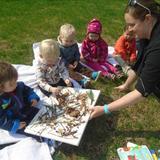 Monroe KinderCare Photo #10 - Miss Karla is teaching her Discovery Preschool class that they can use sticks, leaves and rocks to create an art project outdoors!