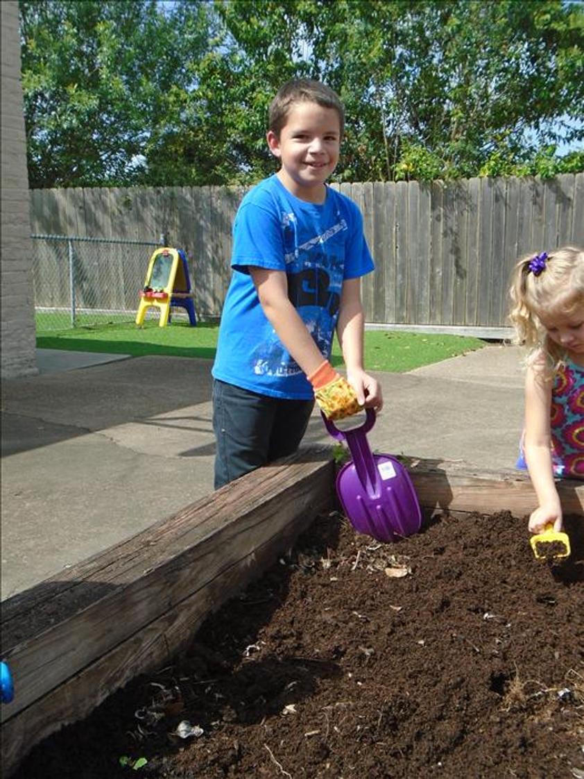 Clear Lake KinderCare Photo - Getting the soil ready for planting our seeds