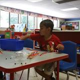 Eden Prairie KinderCare Aztec Photo #6 - Working on counting while making "snakes" with pipe cleaners and beads.