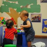 Meadowlands KinderCare Photo #2 - Two young infants practice standing.