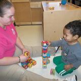 Highland KinderCare Photo - Stacking blocks with his teacher.