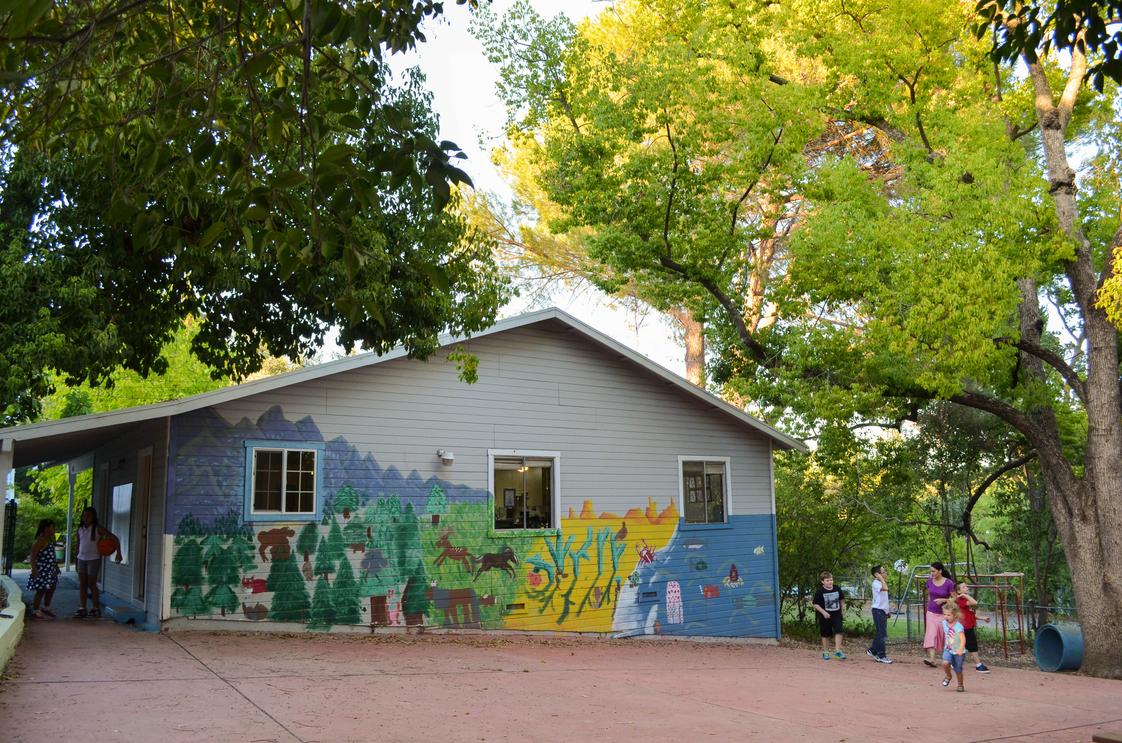 Almondale Academy Photo - Back view of the "Little House" and patio play area. Painting done by students.