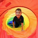 The IDEAL School of Manhattan Photo #7 - A young boy plays in a cloth tunnel during PE class.