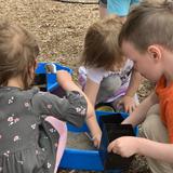 Okc Heartland Montessori School - Future Educ. Llc Photo #4 - We work in our garden all year round. Here, some friends are preparing watermelon seedlings to go in the ground later in the spring!