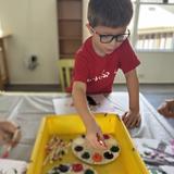 Walden Community School Photo #15 - Curiosity at work! A young learner experiments with color and texture, exploring science through play and observation.