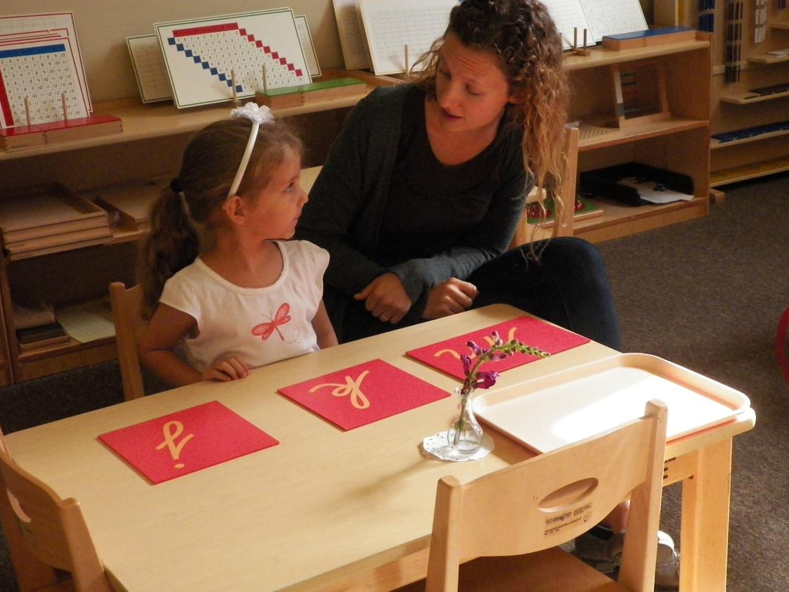 Leport Montessori School Photo - Montessori teacher giving writing lesson