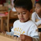 Leport Montessori School Photo #7 - Preschooler with cylinder blocks