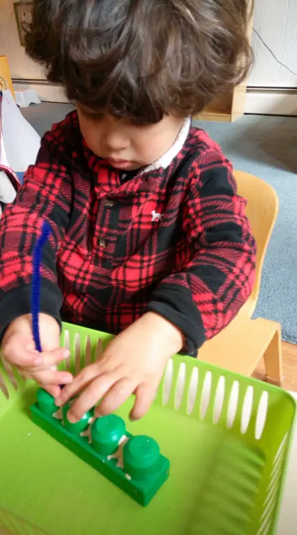 International Montessori Schools At Great Valley Photo #2 - A Pre-Primary child concentrates on a practical life piece of work