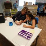 Waves Of Wonder Montessori School Photo #3 - Parent Night is a wonderful opportunity for students to show off their hard work to their families. Here you see one of our Upper Elementary students working with her mother on her lesson.