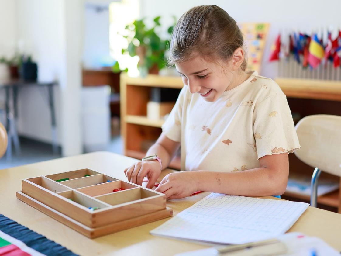 Fraser Woods Montessori School Photo #1 - A Fraser Woods student works independently with Montessori math materials - a hallmark of our hands-on, self-directed approach to learning. Serving students ages 15 months through 8th grade in Newtown, CT. Schedule a tour at fraserwoods.com.