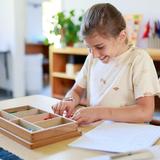 Fraser Woods Montessori School Photo - A Fraser Woods student works independently with Montessori math materials - a hallmark of our hands-on, self-directed approach to learning. Serving students ages 15 months through 8th grade in Newtown, CT. Schedule a tour at fraserwoods.com.