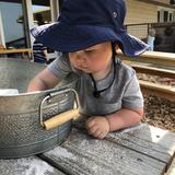 Mountainside Montessori Photo #2 - Each of our classrooms has indoor and outdoor environments. During his morning work, a Toddler chooses to work outside with sand in the Toddler yard.