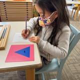 Pinyon Montessori Photo #2 - Engaging with Metal Insets helps children enhance their pencil grip, improve fine motor skills, and acquire the ability to draw within specified outlines, with the material itself serving as a guide for error correction.