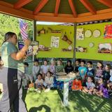 Village Preschool Academy Photo #2 - Joyful moments in our Music Garden Gazebo - children gather for story and music time, where imagination blooms and rhythms come to life. Combining the benefits of music and outdoor learning, this experience supports early language development, enhances social-emotional growth, and nurtures creativity-all while connecting children to the natural world.