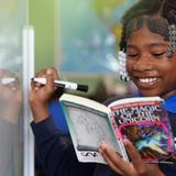 Lake Rose Christian Academy Photo #21 - A Lake Rose Christian Academy student actively engages in her learning, reading while solving a problem at the board.