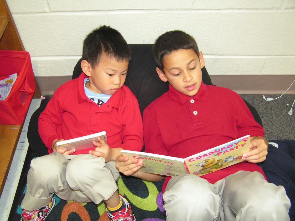 Savannah Adventist Christian School Photo - Reading Buddies. Here, a third grade student shares a great story with a preschooler.